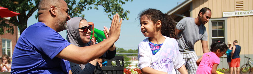 Family high fives during a water play event at the Depot