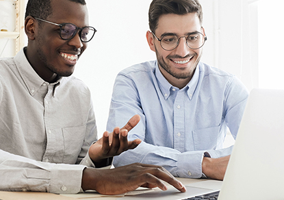 Two men looking up information on a laptop